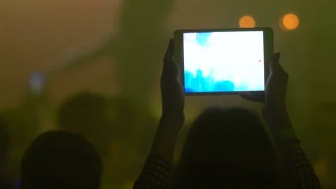 Woman using tablet to record live concert Stock Footage 84780428