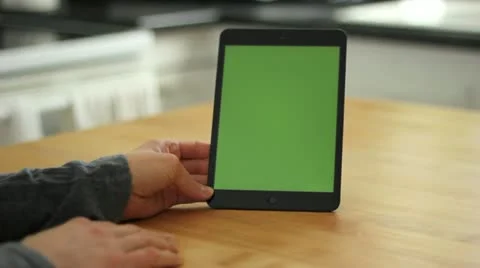 Woman Using Tablet on Wood Table Swipe Left/Right - Green Screen Stock Footage 22222397