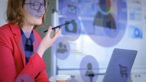Woman using tech reaching for smartphone and dictating while referencing laptop, Stock Footage 333902394