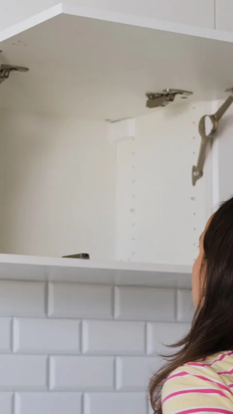 Woman using tools to assemble kitchen cabinet 動画素材 318274165