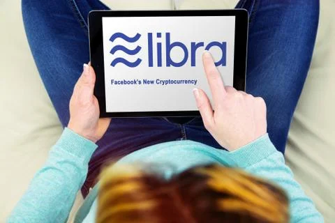 Woman using touch pad with the libra logo, the new crypto currency created by Stock Photos