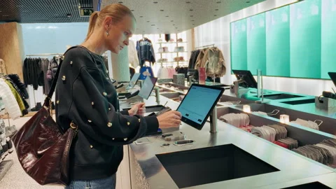 Woman using touch screen checkout terminal in el corte ingles fashion store Stock Footage 336814939