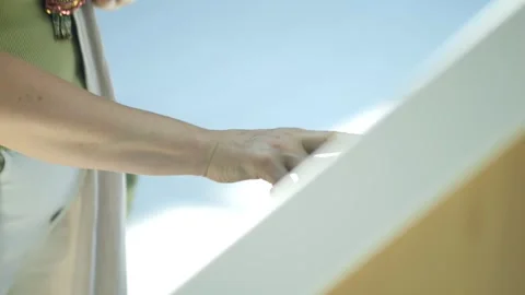 Woman is using a touch screen device, possibly a phone or a tablet Stock Footage 313462663