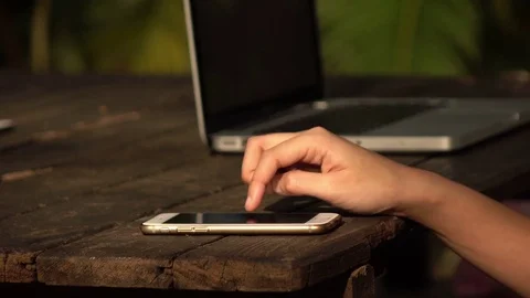 Woman using touch screen on smartphone with wooden desk Stock Footage 73938641