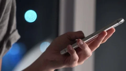 Woman using touch screen on smartphone with bokeh in city night Stock Footage 74761103