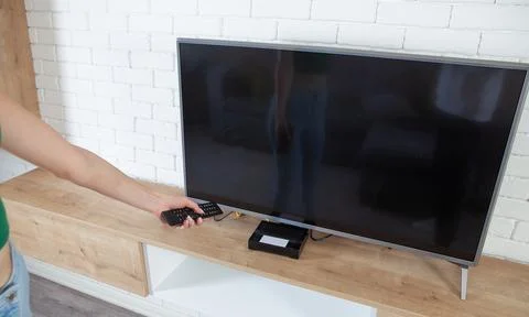 Woman using tv remote controller. Watching tv Stock Photos