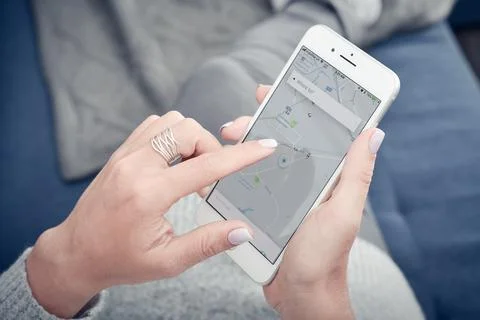 Woman using Uber app on Apple iPhone 8 plus at home Stock Photos