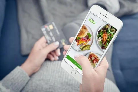 Woman using uber eats app on Apple iPhone 8 plus Stock Photos