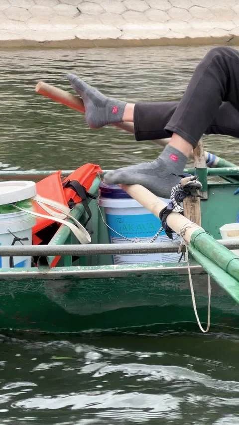 Woman using a unique feet rowing technique on a sampan boat tour in Trang an 스톡 동영상 341752593