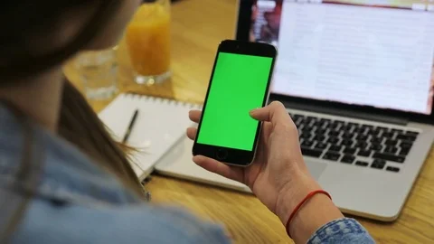 Woman using vertical smartphone with green screen. Close-up shot of woman's Stock Footage 72361272