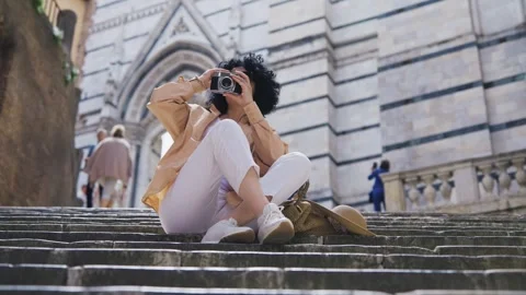 Woman using vintage camera capturing memories in front of a historic Duopmo c Stock-Footage 312950874