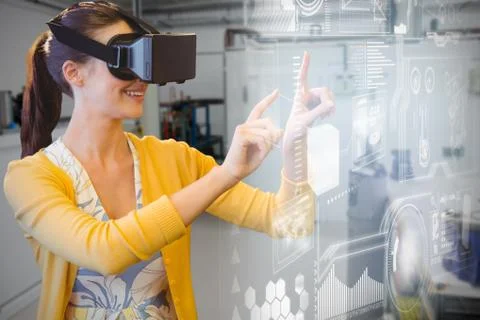 Woman using a virtual reality device against empty workshop in factory Stock Photos