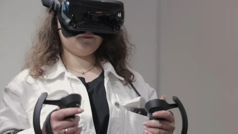 Woman using virtual reality headset indoors. Young woman wearing a high-tech VR Stock Footage 311304453