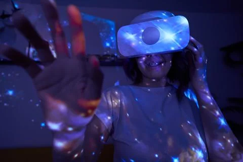 Woman is using virtual reality headset. Elements of this image furnished by NASA Stock Photos