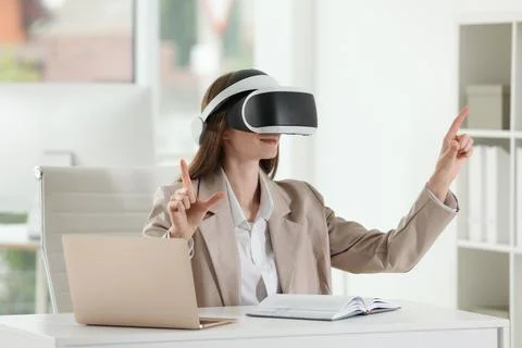 Woman using virtual reality headset in office Stock Photos