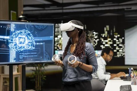 Woman using virtual reality in tech startup office to develop programs using AI Stockfoto's
