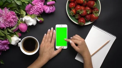 Woman using white smartphone device with green screen. Beautiful white and pink Stock Footage 90674285