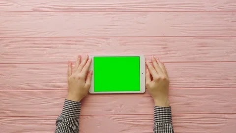 Woman using white tablet computer with green screen on pink wooden background Stock Footage 74722290