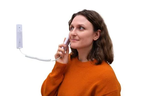 Woman using white wall intercom system. woman talking on wired telephone ha.. Foto stock