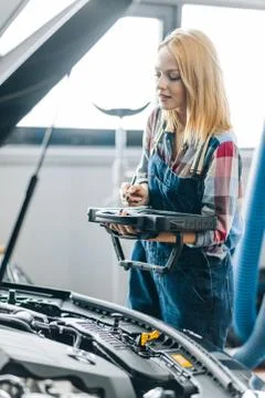 Woman usinga a tool which reports any abnormalities with special error codes. Foto stock