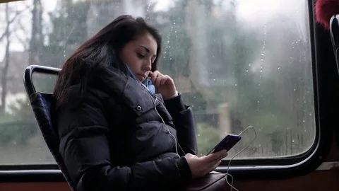 Woman usingphone and dreaming while riding tram Stock Footage 83324219