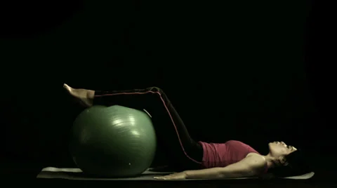 A woman utilizes an exercise ball in her routine Stock Footage 33831380