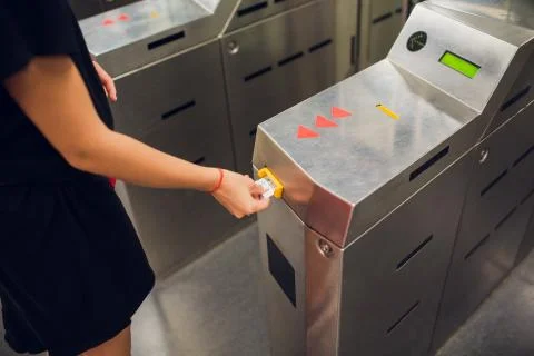 Woman validate ticket in validating machine device to entering at metro station Stock Photos