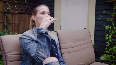 Woman vaping electronic cigarette while having glass of beer 스톡 동영상 64454400