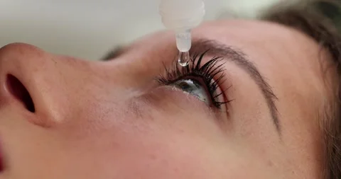 Woman with vision problems drips special drops onto eyeball Stock Footage 257516006