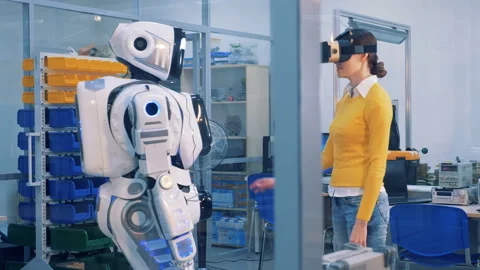 A woman in VR glasses checks robot. Virtual reality game concept. Stock Footage