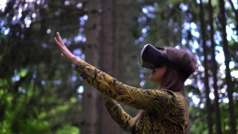 Woman in VR headset looks up at the objects in virtual reality reaching out 스톡 동영상 80130747
