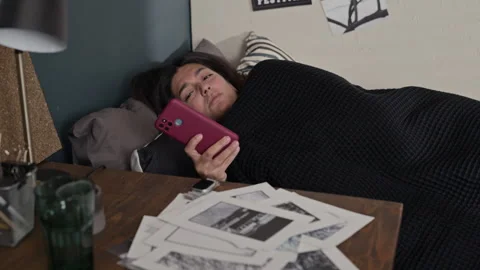Woman Waking up in Bed and Smiling While Checking Her Smartphone Stock Footage 341396830