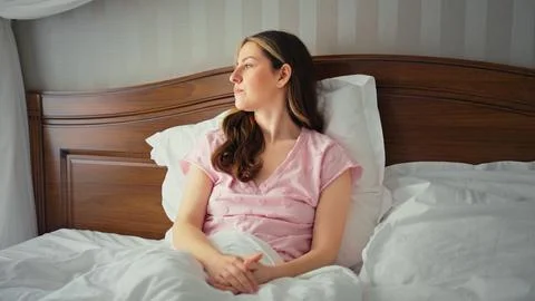 Woman waking up in bed thinking about the day Stock Photos