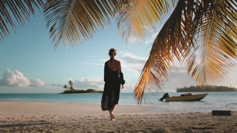 Woman walk under palm tree on sunset sand beach Stock Footage 259923853