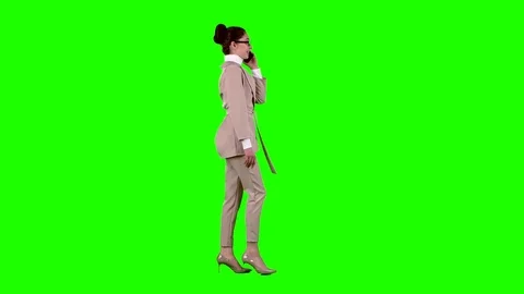 Woman is walking and talking on the phone. Green screen. Side view Stock Footage
