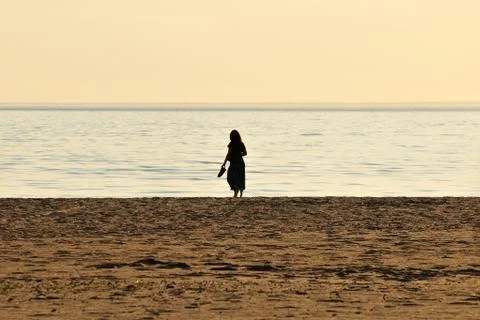 Woman walking on the beach Stock Photos