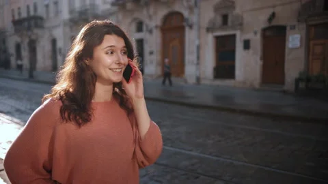 Woman is walking casually while uses on phone, beautiful lady is talking on the Stock-Footage 228615573