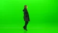The woman walking with a coat on the green background 4k or 4k+ Resolution