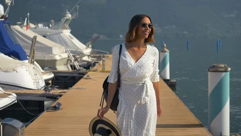 A woman walking on a dock at an Italian lake, slow motion. Stock Footage