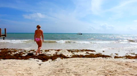 Woman walking down the beach 스톡 동영상 45878283