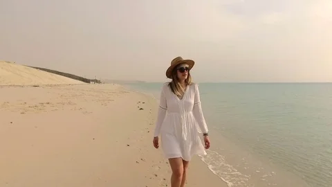 Woman walking down a beach Stock Footage 75568055