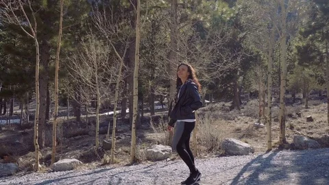Woman walking down dirt path next to forest Stock Footage 74613447