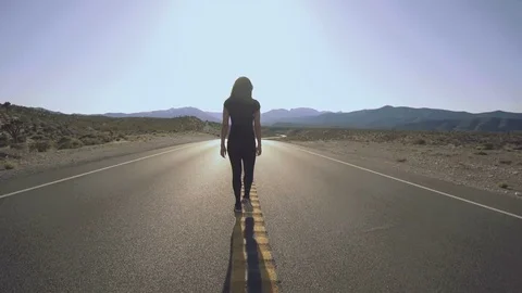 Woman Walking Down Empty Road In Nevada Desert Stock Footage 74613312
