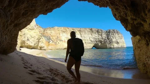 Woman Walking Down An Empty White Sand Beach With Seaside Cliffs 스톡 동영상 114643295