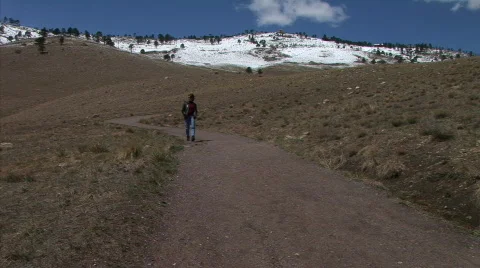Woman walking down the mountain trail 1 Stock Footage