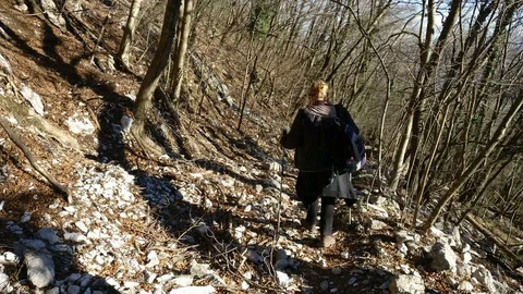 Woman walking down the path on a mountain with Scandinavian sticks Stock Footage 91809846
