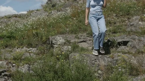 Woman walking down rocks Stock Footage 78569670