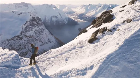 Woman walking down on sharp mountain ridge with fjord view Stock Footage 99838998