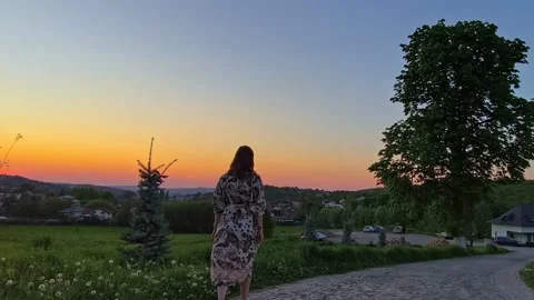 Woman walking down a stone path during a vibrant sunset. Stock-Footage 334557035