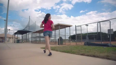 Woman walking by empty baseball field, steadicam shot Stock Footage 62854859